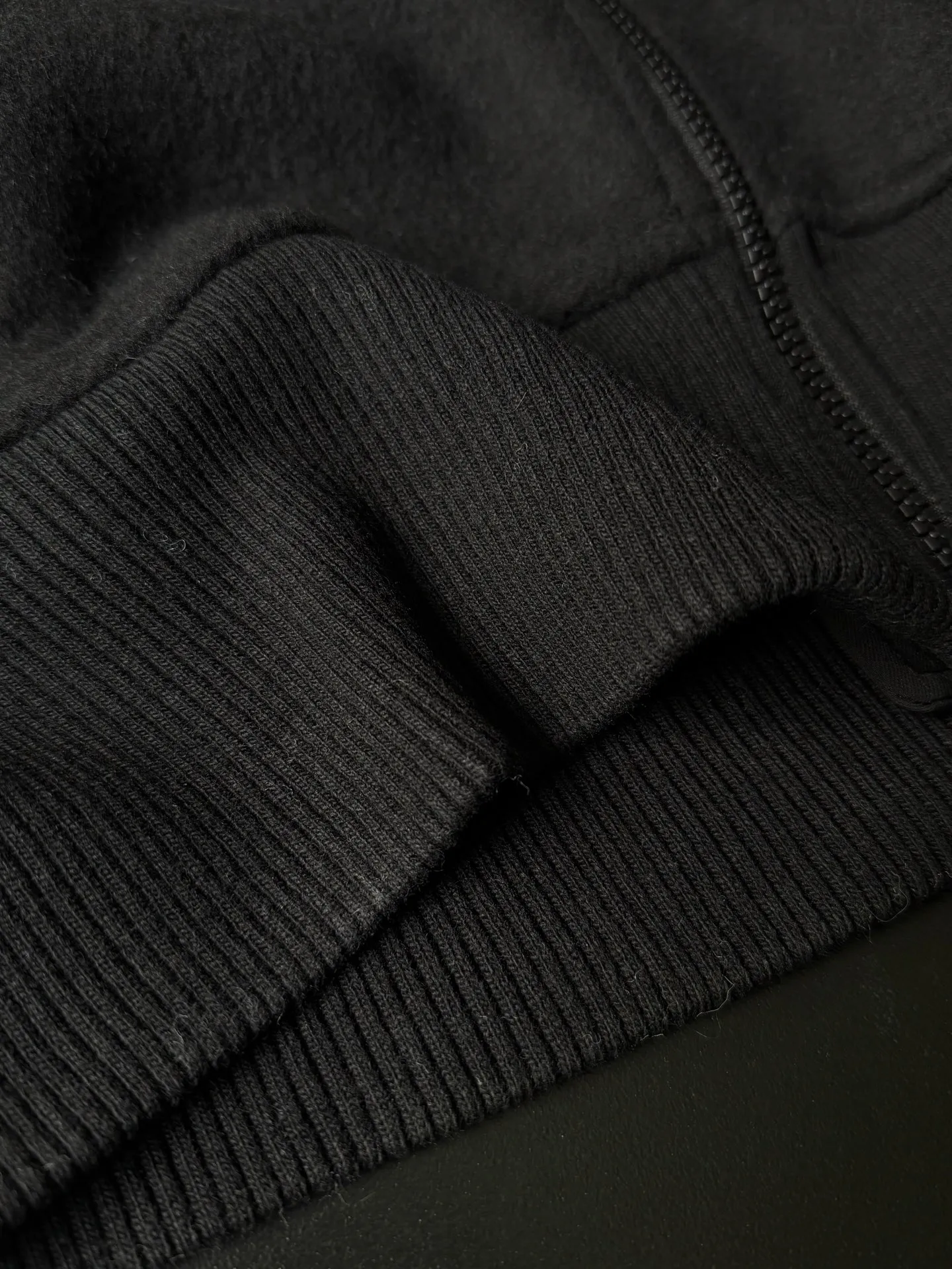 P620 Canada Goose Fleece Wool Baseball Jacket Fabric selection: Wool fleece fabric blended with wool as the main body and a very small amount of spandex and polyester fiber. Wool is a core natural ingredient that provides unparalleled temperature regulation, antibacterial and anti-odor properties and a skin-friendly feel. The feeding of a small amount of spandex gives the fabric a certain degree of four-way elasticity, making it non-restrictive during daily activities. As the basis of fleece's structure, polyester fiber enhances the fabric's durability, wrinkle resistance and quick-drying properties. It contributes to the loft of the fleece and provides functions such as trapping air.  Detail 1: The sleeves and hem are closed with 2×2 ribbing. Its strong elasticity can closely fit wrists and waists of different thicknesses, forming an effective 'seal' to prevent cold wind from blowing back. It can still maintain its original shape after repeated stretching and use, and is not easy to loose and deform. And the ribbed cuffs can convey a sense of design and enhance the visual beauty.  Detail 2: The combination of hood design and elastic buckle improves warmth and windproof performance when wearing. Accessories: Customized elastic drawstring, elastic buckle, custom zipper pendant, custom armband Size: S M L Color: Black Gray Mickey